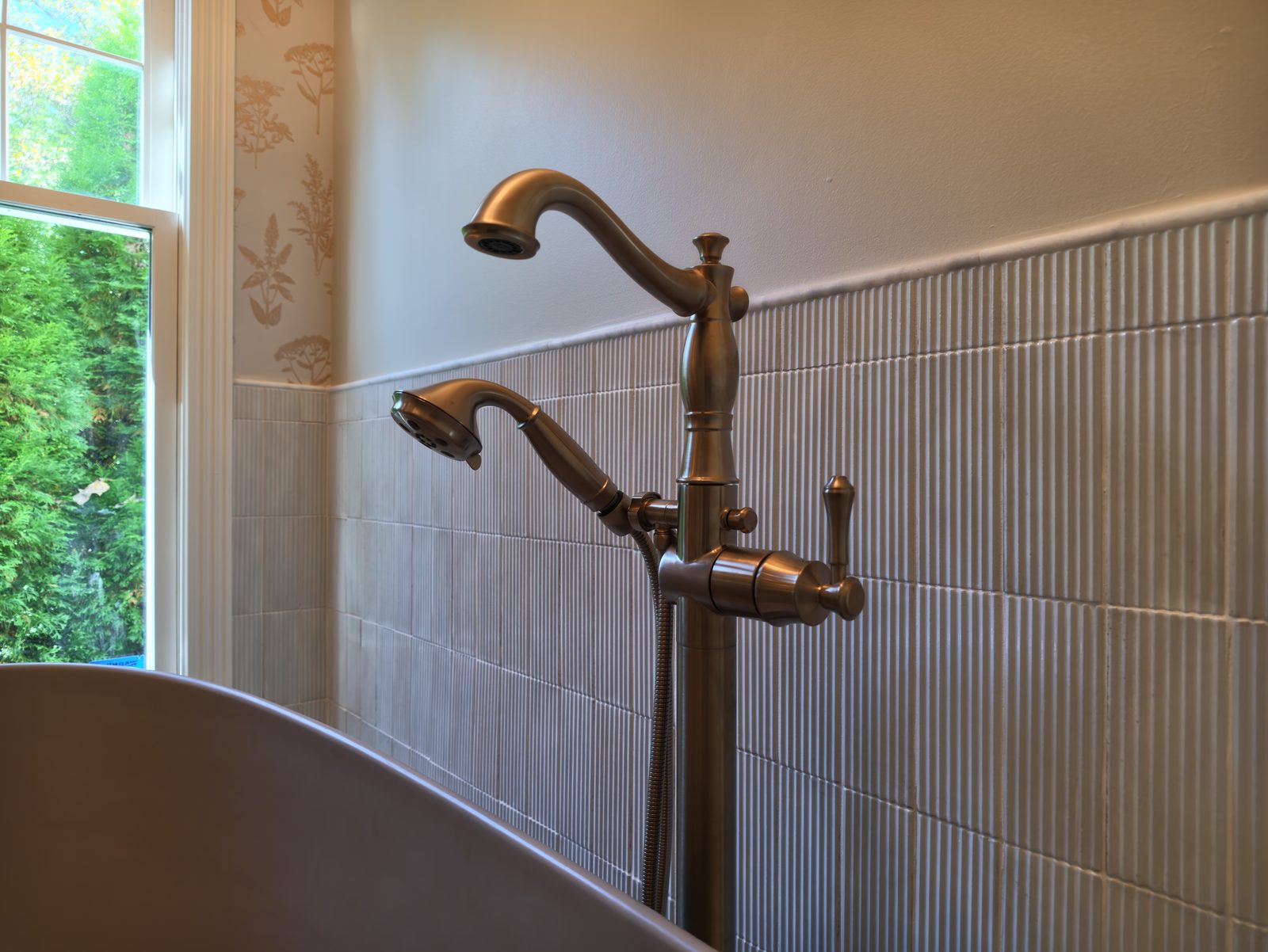 Floor mounted champagne bronze tub filler beside freestanding tub Noblesville Indiana
