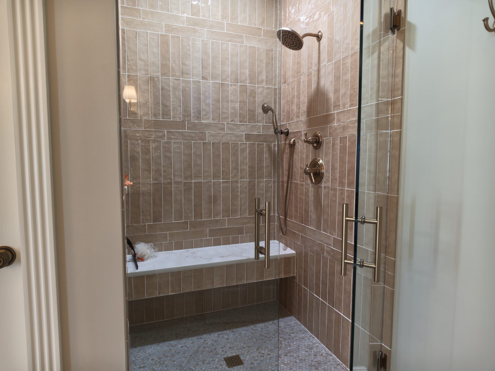 Walk-in shower interior with stone topped bench and vertical stacked tile Noblesville IN