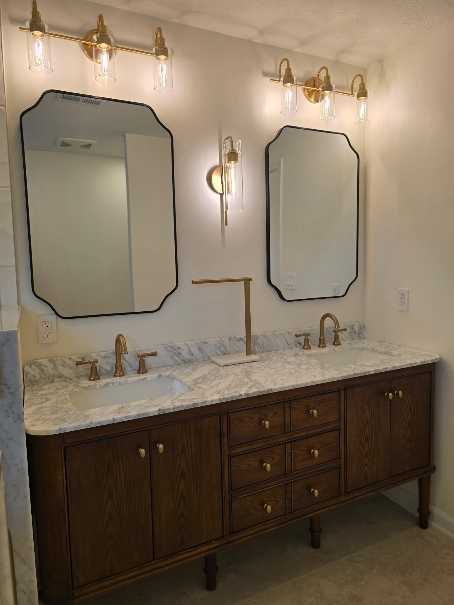 Dark stained double vanity with marble countertop and octagonal mirrors Fishers IN