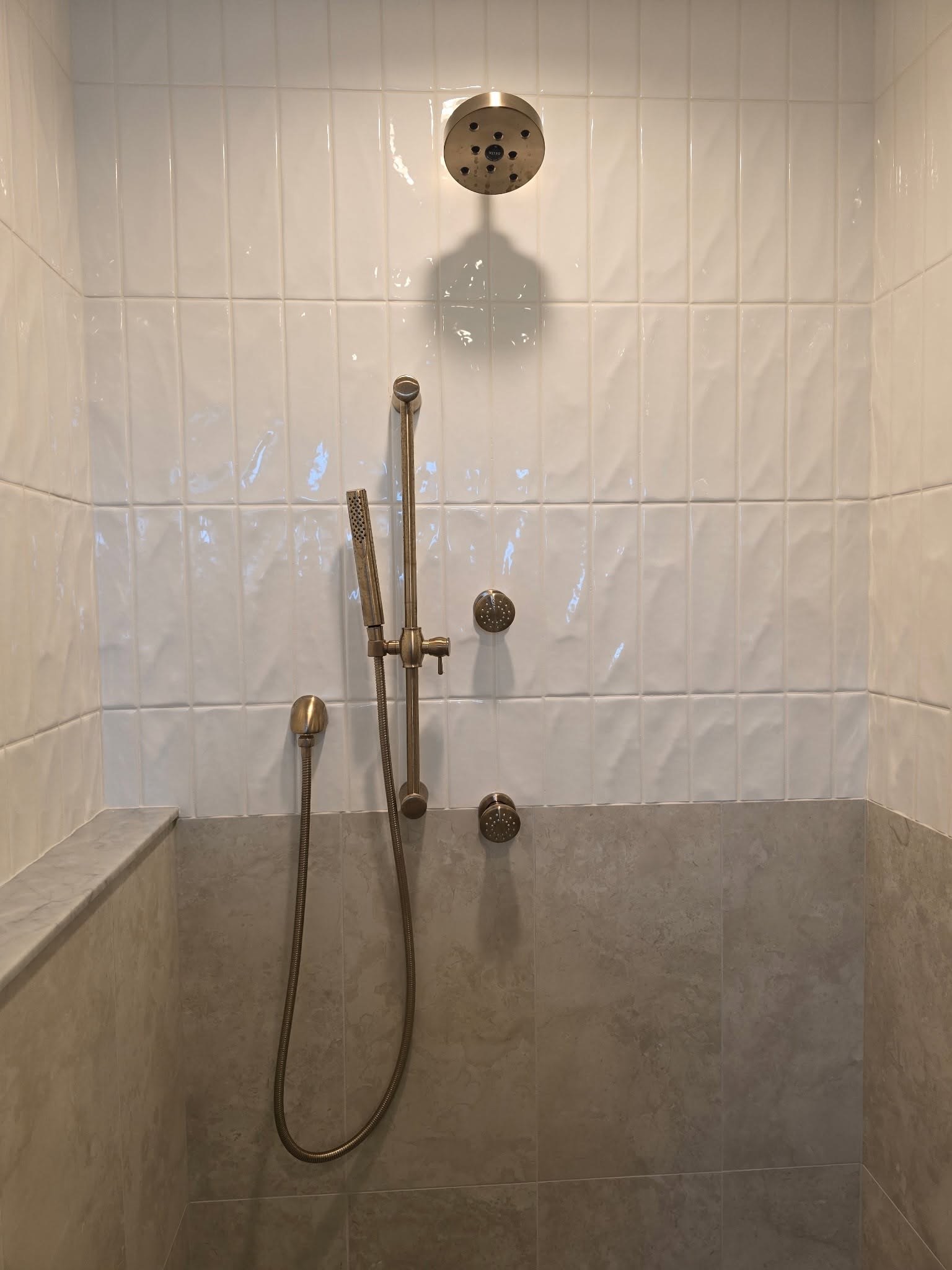 Walk-in shower with handheld on slide bar and textured white wall tile Fishers Indiana
