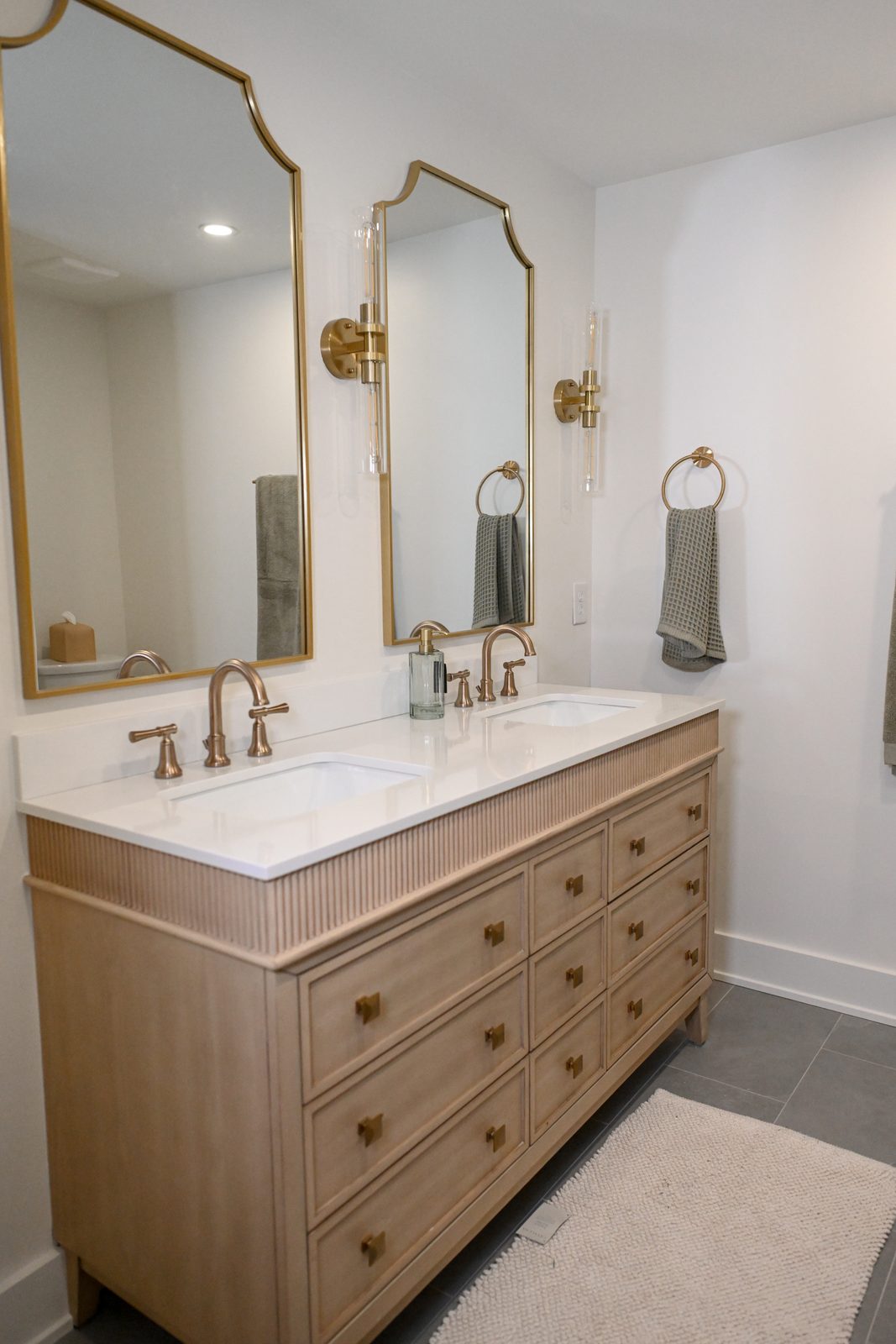 Basement bathroom fluted white oak double vanity with brass fixtures Westfield Indiana