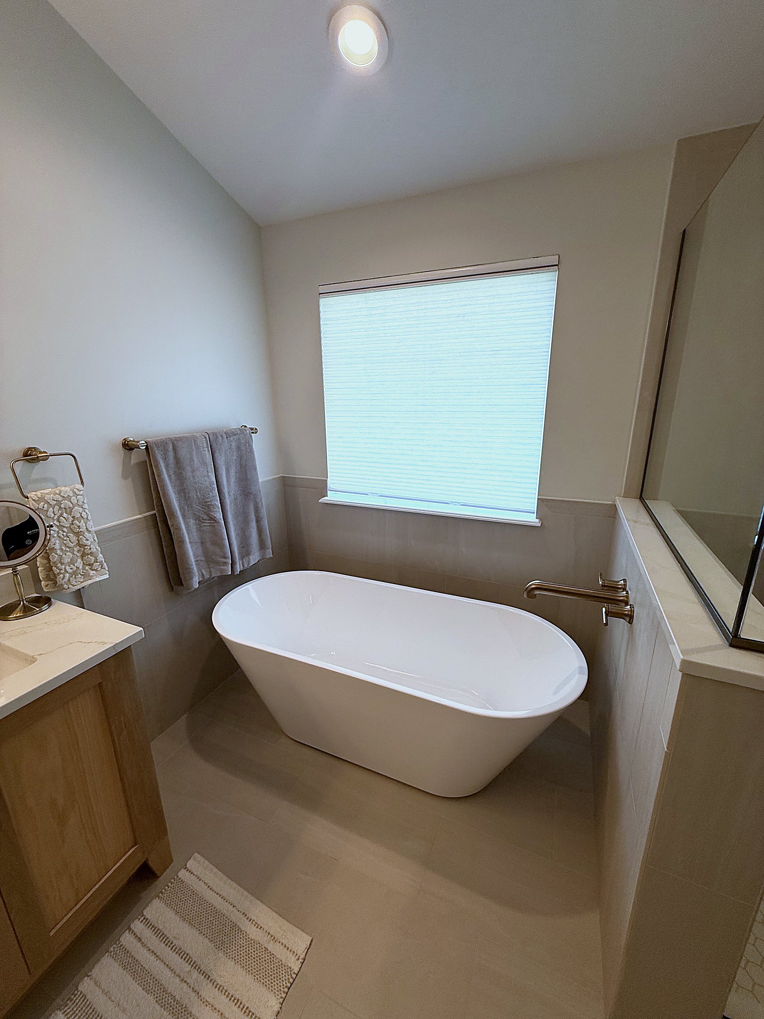 Freestanding soaking tub with wall mount filler and large format porcelain tile Fishers IN