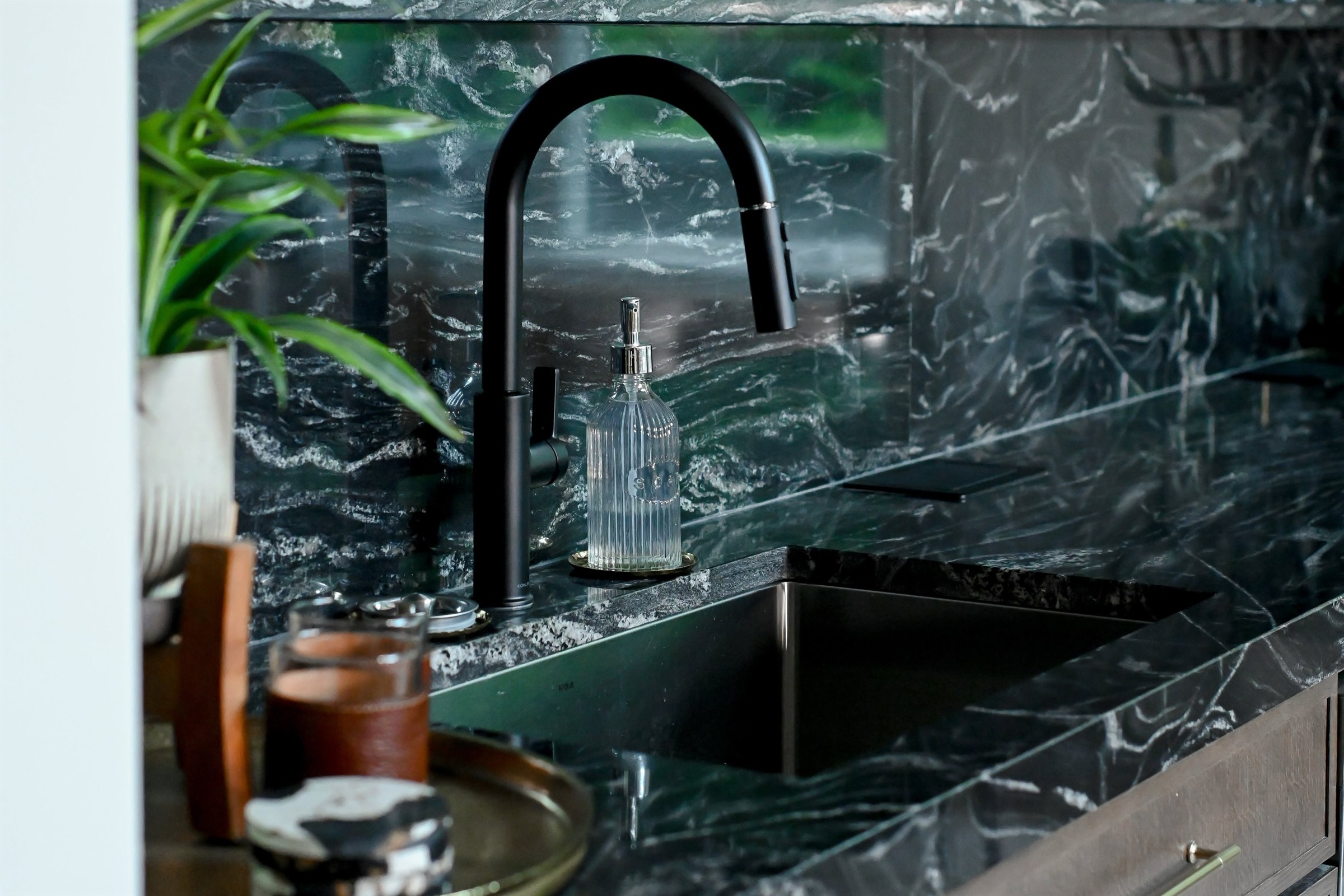 Undermount bar sink with matte black faucet and stone slab backsplash Zionsville Indiana basement