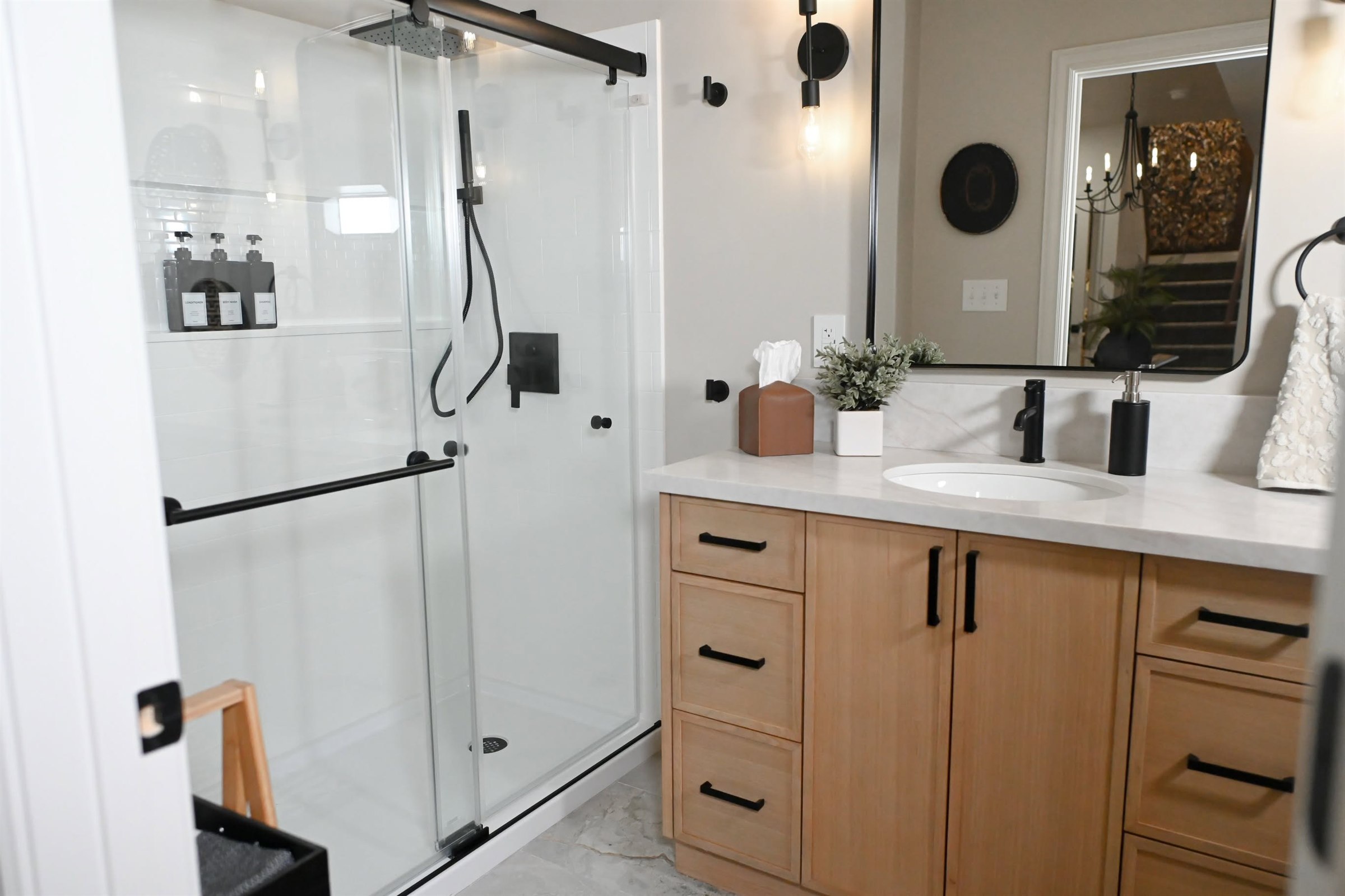 Basement guest bathroom with tiled glass shower and white oak vanity Zionsville Indiana
