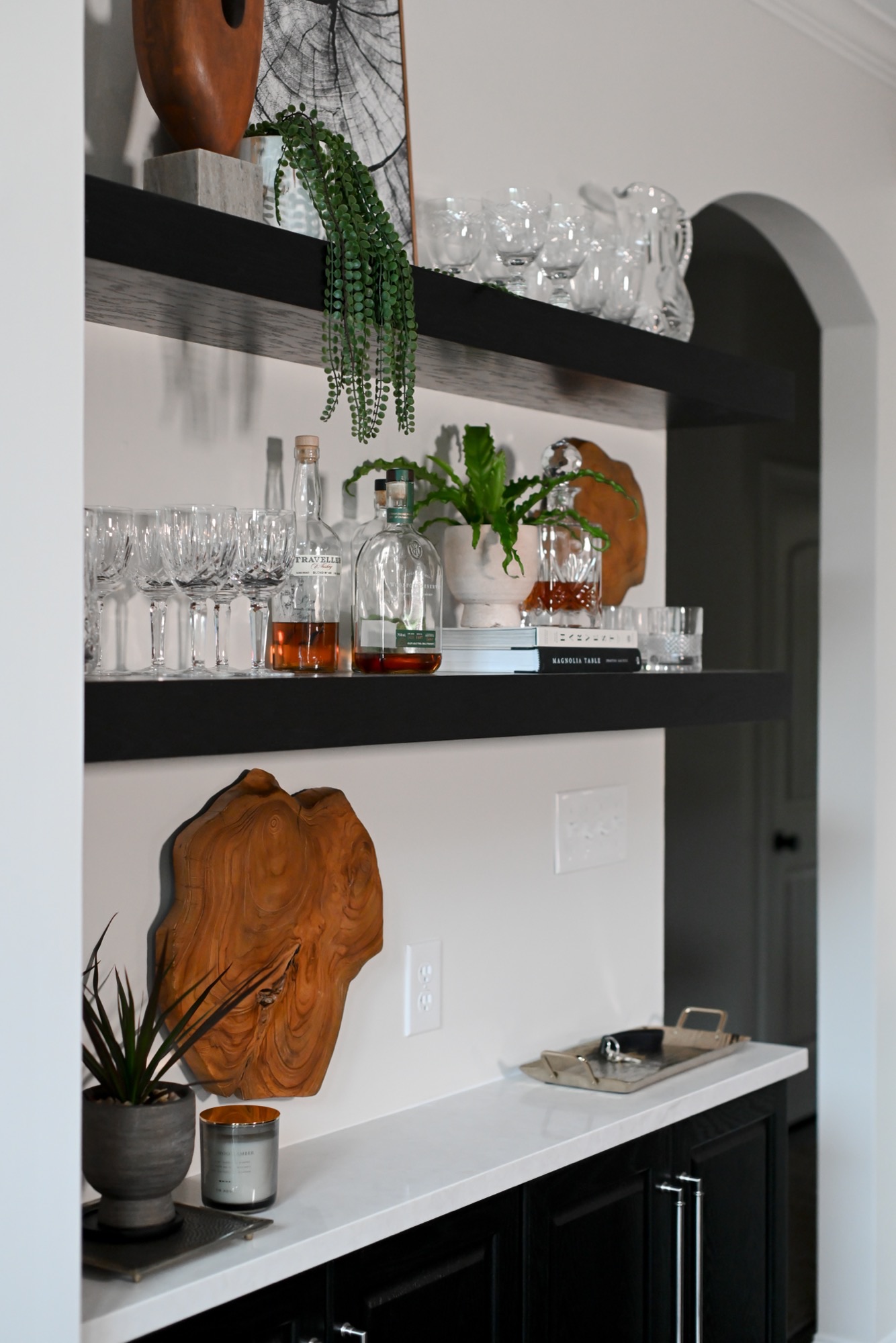 Butler bar niche with black floating shelves and stone counter Zionsville IN